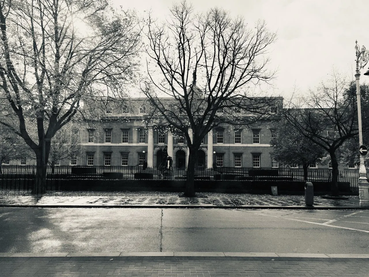 Black-and-white photograph of a Georgian building behind bare trees on a Dublin street